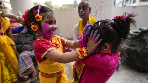 Девочки раскрашивают друг друга пудрой в дни праздника Холи в Калькуте, Индия - Sputnik Грузия