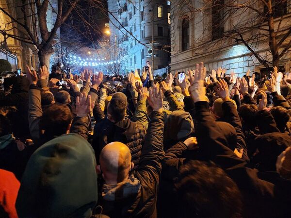 Протестующие у здания парламента поднимали руки вверх, чтобы показать, что они безоружны и это мирная акция протеста - Sputnik Грузия