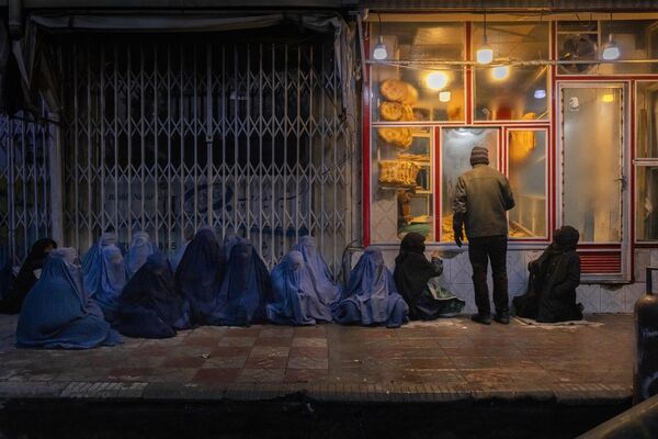 Снимок из серии &quot;Цена мира в Афганистане&quot; датского фотографа Мадса Ниссена.На фото изображены женщины и дети, которые просят милостыню возле пекарни в центре Кабула. - Sputnik Грузия