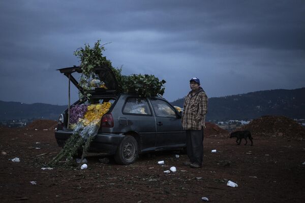 Мужчина продает цветы, выставляя их в припаркованной машине на цветочном рынке Вилла Герреро в Мексике. Снимок фотографов Кристофера Рожель Бланка (Мексика) и   В. Юджина Смита Гранта (США). - Sputnik Грузия