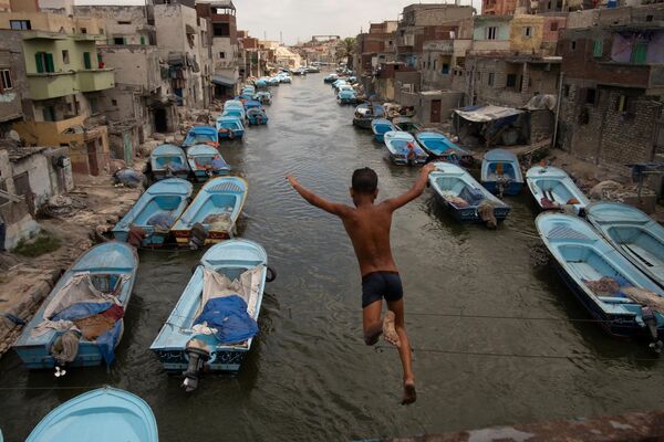 Африканский ребенок прыгает с пирса в водный канал. Снимок египетского фотографа Мохамеда Махди  - Sputnik Грузия