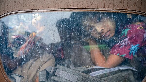 Девочка выглядывает из тук-тука во время эвакуации в Ситтве, Мьянма - Sputnik Грузия