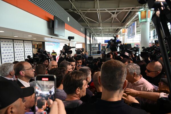 Внутри здания аэропорта было шумно – репортеры пытались взять интервью у всех прибывающих пассажиров. - Sputnik Грузия