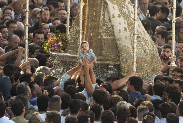 Паломники прикладывают младенца к изображению Пресвятой Девы во время ежегодного паломничества в деревню Эль-Росио, Испания. - Sputnik Грузия