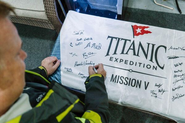 Британский миллиардер и космический турист Хамиш Хардинг подписывает флаг пятой экспедиции к обломкам &quot;Титаника&quot;. - Sputnik Грузия