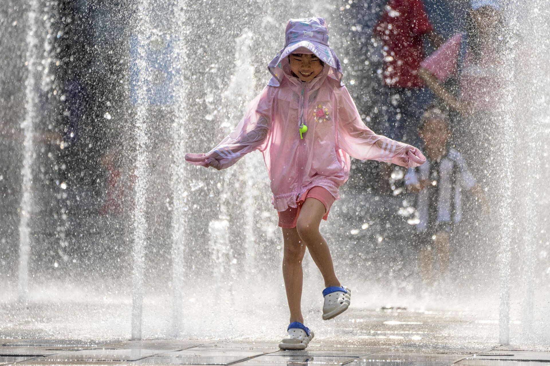 Девочка играет в фонтане во время жаркого дня у торгового центра в Пекине - Sputnik Грузия, 1920, 18.07.2023