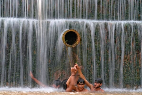 Молодые люди купаются в водопаде. Температура в Исламабаде достигла рекордных 36 градусов. - Sputnik Грузия