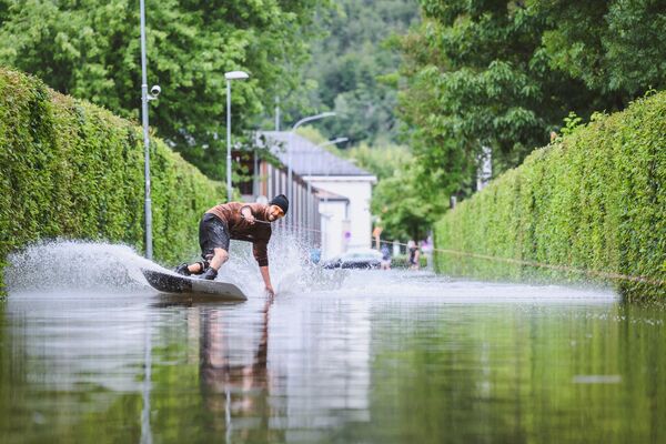 Вейкбордист на затопленной дороге в Клагенфурте, Австрия. - Sputnik Грузия