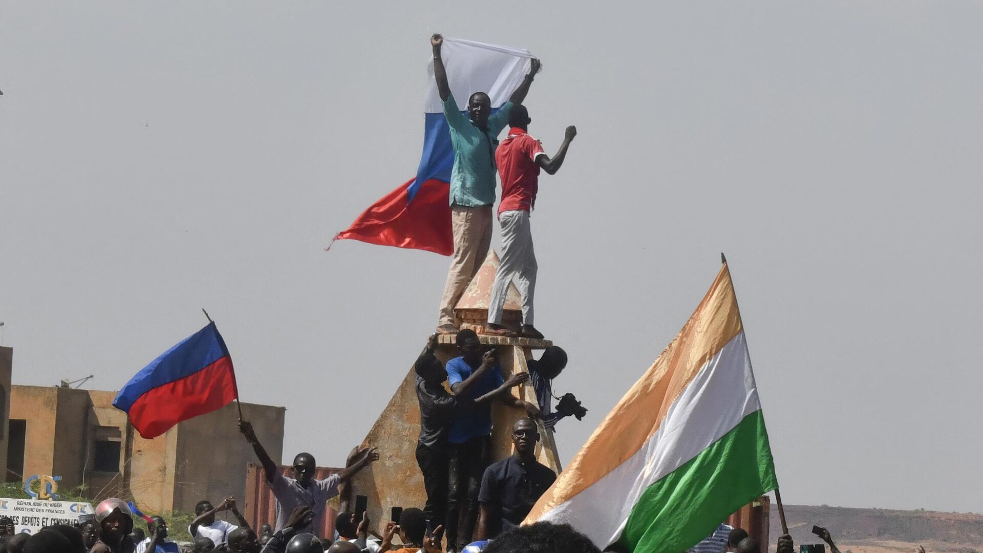 Протестующие размахивают нигерийскими и российскими флагами, собираясь во время митинга в поддержку нигерийской хунты в Ниамее - Sputnik Грузия, 1920, 20.08.2023