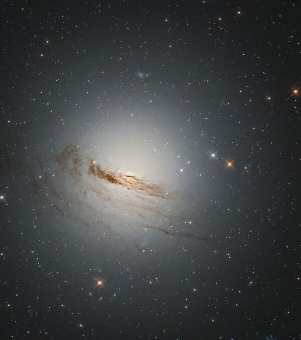 Линзовидная галактика NGC 1947 потеряла почти весь газ и пыль из своих спиральных рукавов, которые раньше вращались вокруг ее центра. - Sputnik Грузия