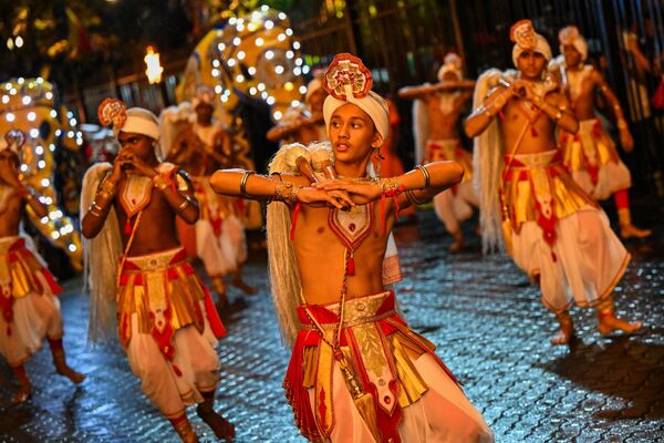 Танцоры выступают перед историческим буддийским храмом Зуба во время процессии в честь фестиваля Эсала Перахера в древней горной столице Канди. - Sputnik Грузия