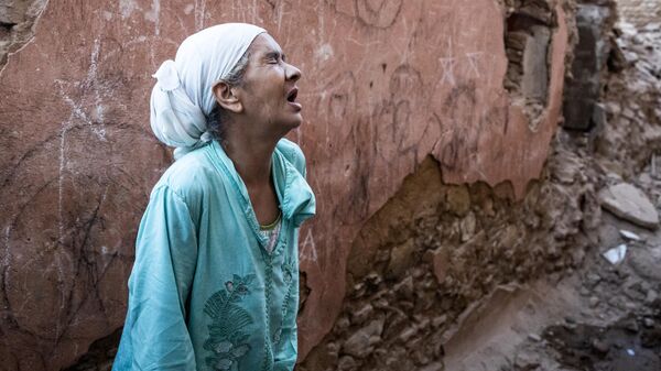 Женщина стоит перед своим поврежденным домом от землетрясения в старом городе Марракеша, Марокко - Sputnik Грузия