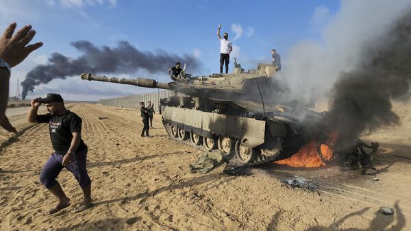 Палестинцы на границе с Израилем радуются у захваченного и взорванного израильского танка - Sputnik Грузия