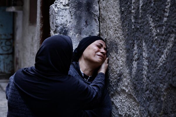 Родственники погибших плачут во время похорон в Палестине. - Sputnik Грузия