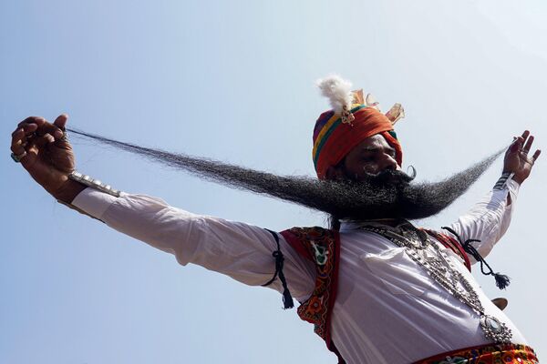 Мужчина демонстрирует свои усы во время конкурса усов на ежегодной ярмарке в Пушкаре, Индия. - Sputnik Грузия