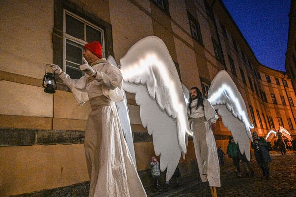 Артисты в костюмах ангелов идут на ходулях во время рождественского парада ангелов 17 декабря в Праге. - Sputnik Грузия