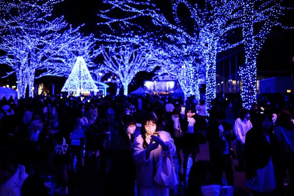 Люди фотографируются с праздничными световыми инсталляциями в преддверии рождественского сезона в токийском районе Сибуя. - Sputnik Грузия