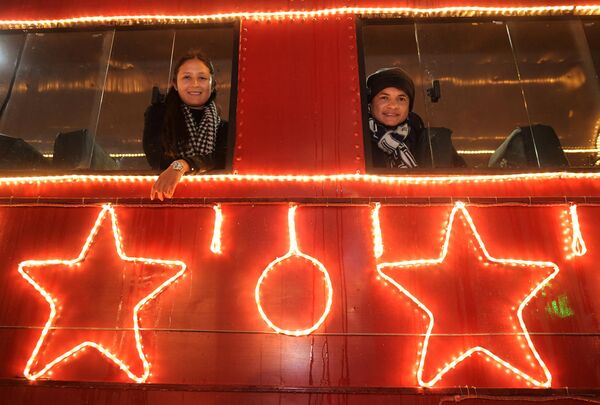Любители Рождества позируют фотографам на вокзале Усакен поезда Сабана, украшенном рождественскими гирляндами. - Sputnik Грузия