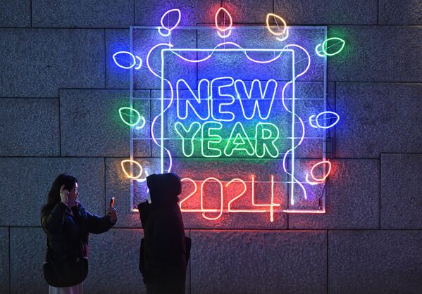 Люди фотографируются перед световым табло с надписью &quot;Новый 2024 год&quot; в центре Сеула. - Sputnik Грузия
