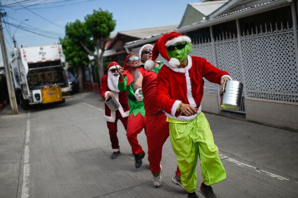 Сборщики мусора в костюмах рождественских персонажей собирают чаевые в Сантьяго. - Sputnik Грузия