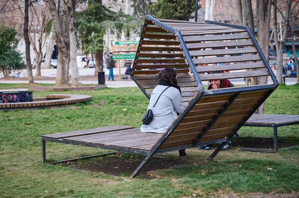 А тут в одном из парков девушки сидят и о чем-то беседуют на лавочке. Температура вполне комфортна для такого времяпрепровождения. - Sputnik Грузия