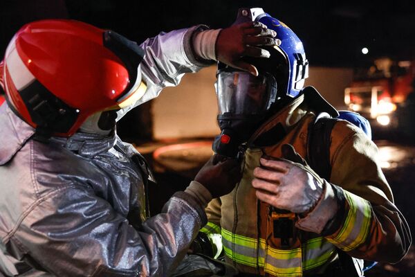 Пожарный поправляет кислородную маску своего коллеги на месте взрыва в Найроби. - Sputnik Грузия