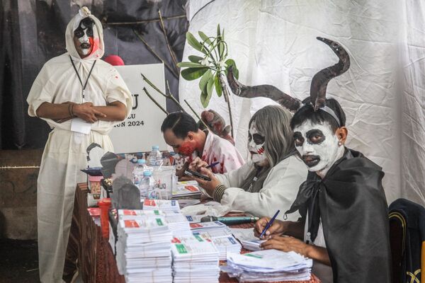 Сотрудники, одетые в костюмы ужасов, работают на избирательном участке во время президентских и парламентских выборов в Индонезии. - Sputnik Грузия