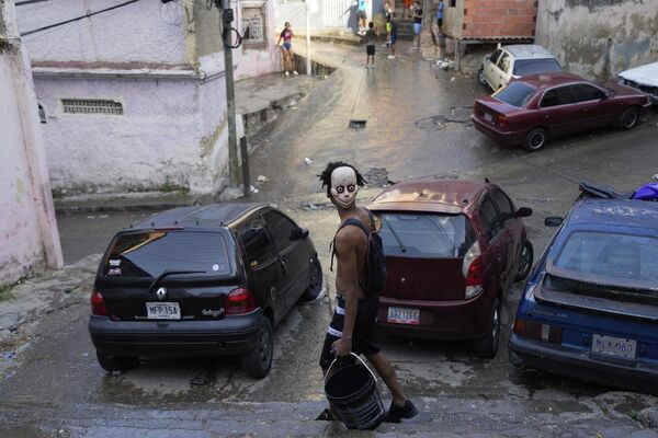 Мужчина с ведром во время празднования карнавала в Каракасе. - Sputnik Грузия