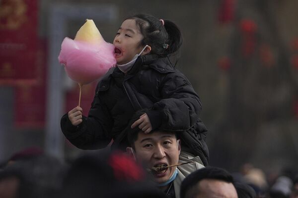 Мужчина несет своего ребенка на плече во время второго дня празднования лунного Нового года в Пекине. - Sputnik Грузия