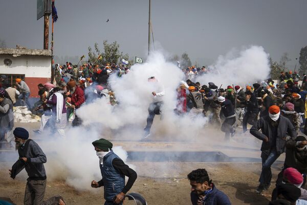 Протестующие фермеры убегают от снарядов со слезоточивым газом в Индии. - Sputnik Грузия