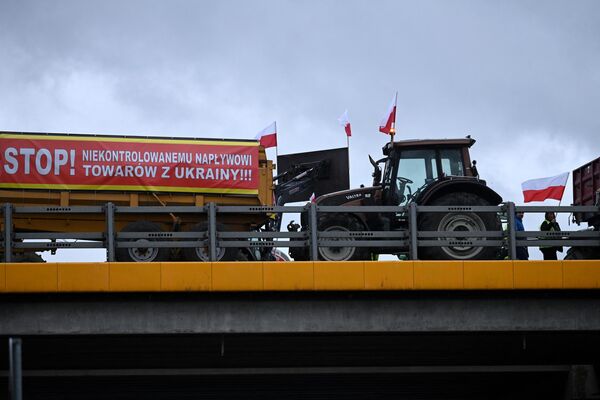 Баннер с надписью &quot;Стоп бесконтрольным поставкам товаров из Украины&quot; на тракторном прицепе. Польские фермеры заблокировали шоссе, соединяющее Варшаву и Люблин, возле города Рыки во время акции протеста 20 февраля. - Sputnik Грузия