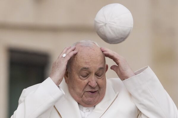 Папа Римский Франциск пытается поймать свой головной убор, который сдуло ветром. - Sputnik Грузия