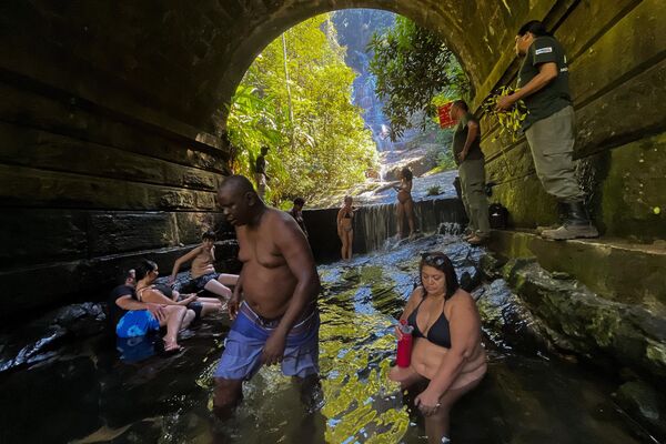 Люди охлаждаются у водопада Таунай в национальном парке Тижука в Рио-де-Жанейро. - Sputnik Грузия