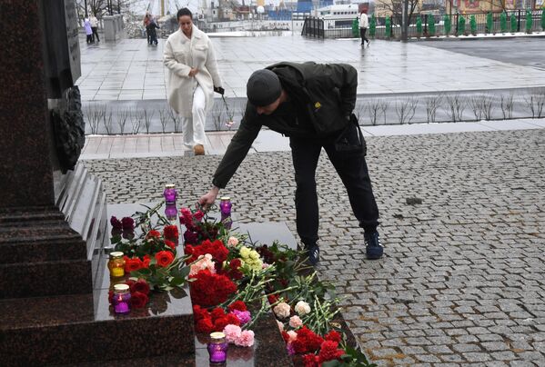 Мужчина возлагает цветы у стелы &quot;Владивосток – город воинской славы&quot; во время акции в память о жертвах теракта в подмосковном &quot;Крокус Сити Холле&quot;. - Sputnik Грузия