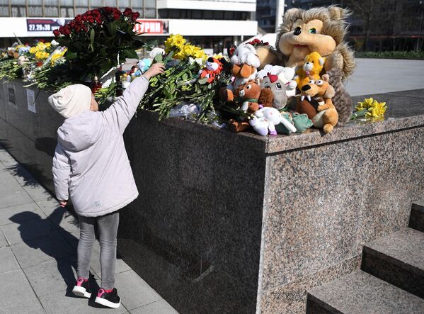Девочка возлагает цветы к стихийному мемориалу на площади Ленина в Симферополе. - Sputnik Грузия