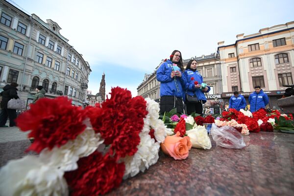 Люди возлагают цветы на улице Баумана в Казани во время акции в память о жертвах теракта в подмосковном Крокус Сити Холле - Sputnik Грузия
