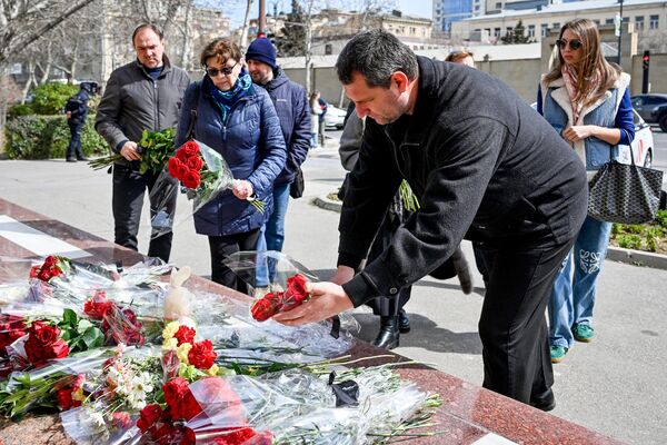 Люди возлагают цветы к стихийному мемориалу у посольства Российской Федерации в Баку. - Sputnik Грузия