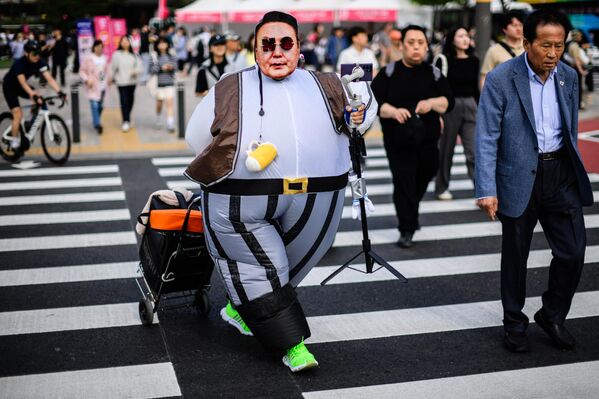 Активистка в костюме с изображением президента Южной Кореи Юн Сок Ёля во время митинга в честь Дня труда в Сеуле. - Sputnik Грузия