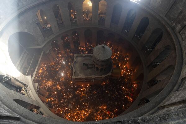Христианские паломники держат свечи во время церемонии Благодатного огня за день до Пасхи в храме Гроба Господня в Иерусалиме. - Sputnik Грузия
