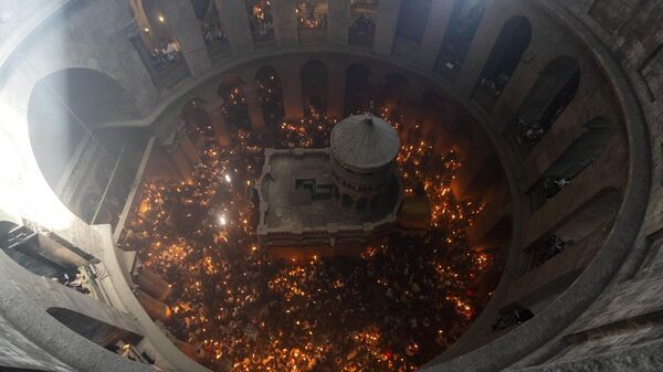 Христианские паломники держат свечи во время церемонии Благодатного огня за день до Пасхи в храме Гроба Господня, Иерусалим - Sputnik Грузия