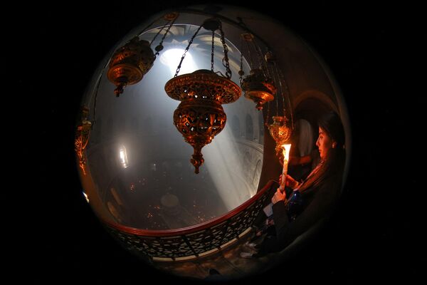 Христианские паломники держат свечи во время церемонии Благодатного огня. - Sputnik Грузия