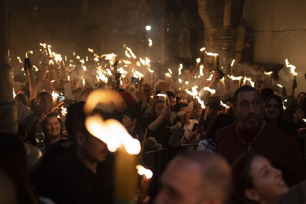Христианские паломники держат свечи во время церемонии Благодатного огня за день до Пасхи в храме Гроба Господня. - Sputnik Грузия