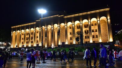 Акция протеста оппозиции ночью у парламента во время дождя 
