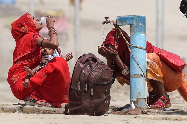 Женщины пьют воду жарким летним днем в Праяградже, Индия. - Sputnik Грузия