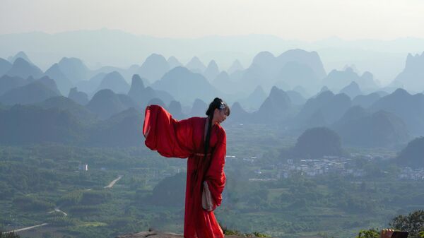 Туристка на фоне гор и рек Янмейлин (также известных как Тысяча миль гор и рек) в городе Гуйлинь, Китай - Sputnik Грузия