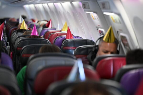 Пассажиры на борту VA925, следующего из Сиднея в Брисбен, в праздничных колпаках в честь 25-летия авиакомпании Virgin Australia. - Sputnik Грузия
