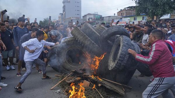 Протестующие против запрета социальных сетей и коррупции жгут покрышки во время комендантского часа в Катманду, Непал - Sputnik Грузия