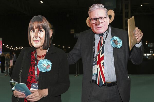 Члены Партии реформ в масках, изображающих премьер-министра Великобритании Кира Стармера и канцлера казначейства Великобритании Рэйчел Ривз, во время ежегодной конференции Партии реформ в Англии. - Sputnik Грузия