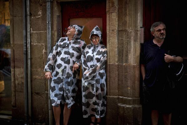 Люди прячутся от проливного дождя во время празднования Национального дня Каталонии в Барселоне. - Sputnik Грузия