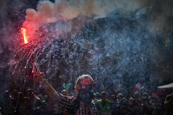 Протестующий держит факел во время многотысячного марша по центру Парижа во время демонстраций. - Sputnik Грузия